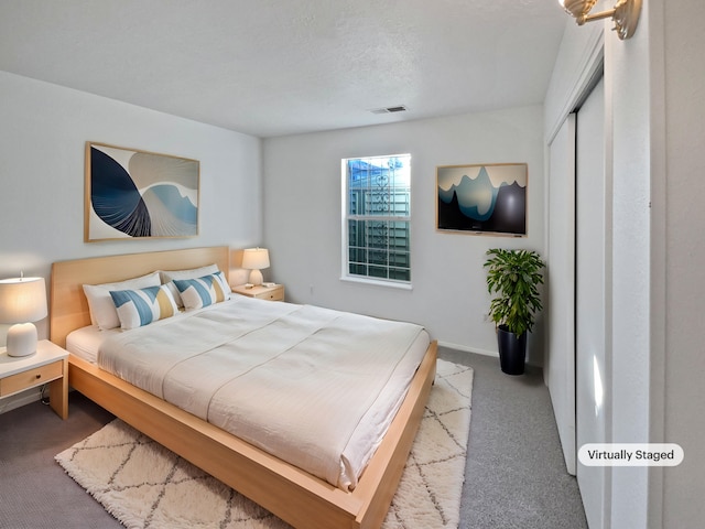 bedroom with light carpet and a textured ceiling