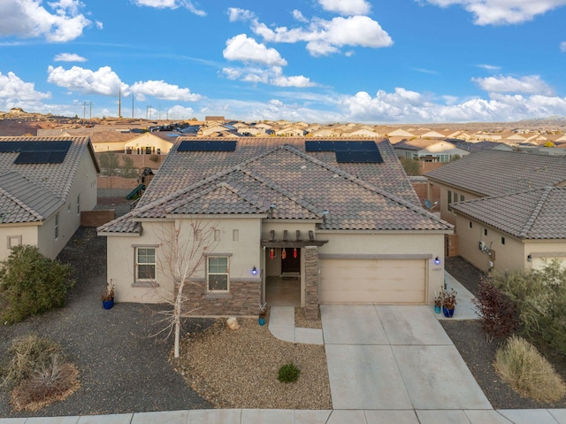 view of front of property with solar panels and a garage