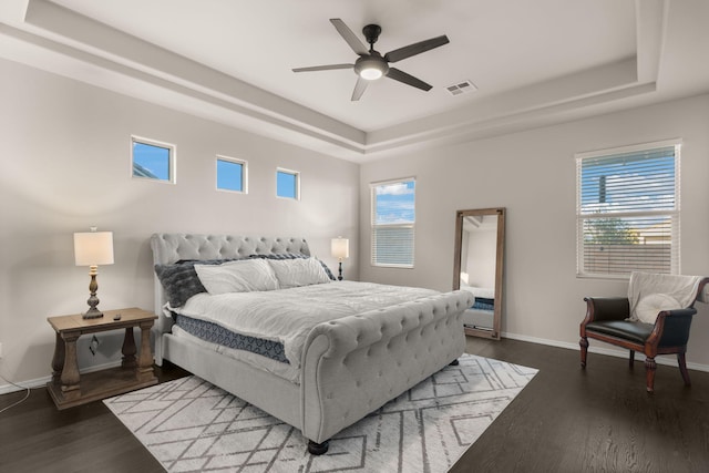 bedroom with multiple windows, a raised ceiling, and ceiling fan