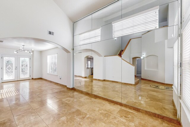 interior space with a towering ceiling and an inviting chandelier