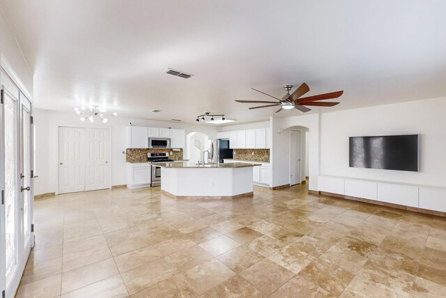 unfurnished living room with sink and ceiling fan with notable chandelier