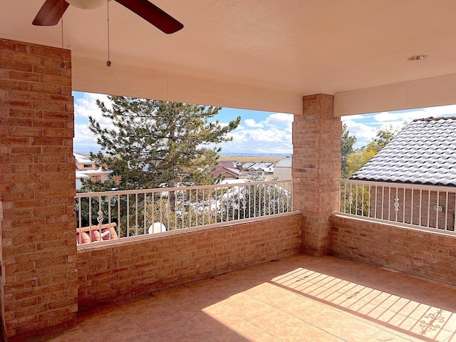 view of patio with ceiling fan and a balcony