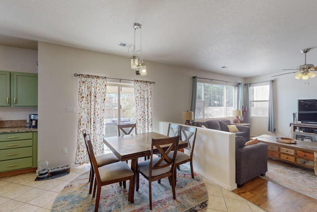 dining room featuring light tile patterned flooring, ceiling fan, and a textured ceiling