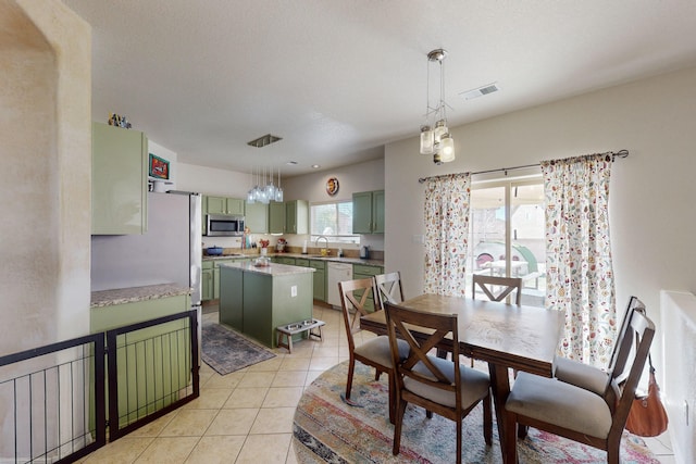 dining space featuring sink and light tile patterned flooring