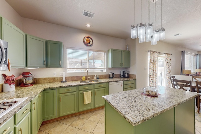 kitchen with sink, white appliances, a center island, and green cabinets