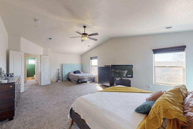 carpeted bedroom featuring ceiling fan, vaulted ceiling, and a textured ceiling