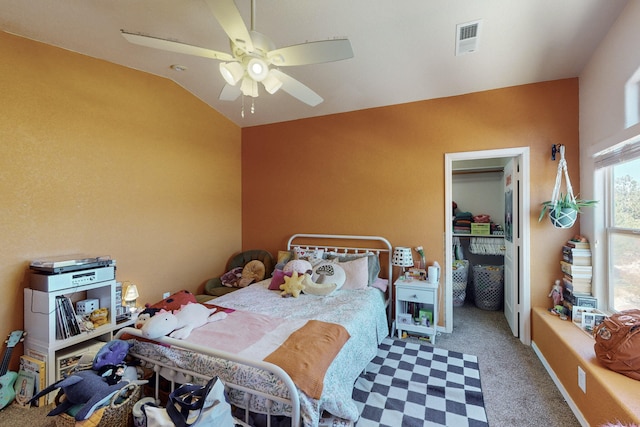 carpeted bedroom with a spacious closet, vaulted ceiling, a closet, and ceiling fan