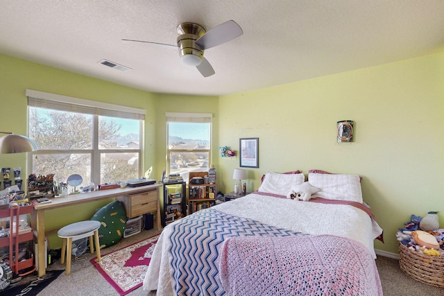 bedroom with carpet floors, a textured ceiling, and ceiling fan