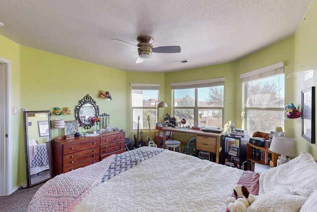 bedroom featuring ceiling fan, light carpet, and a textured ceiling