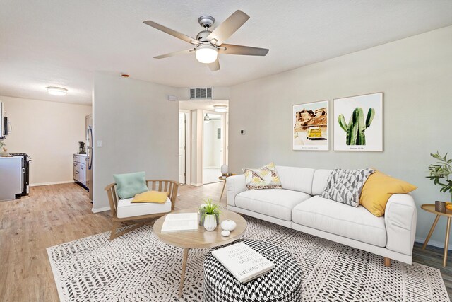 living room with ceiling fan and light hardwood / wood-style flooring