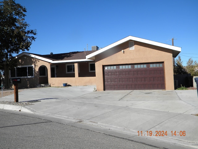 view of front facade featuring a garage and cooling unit