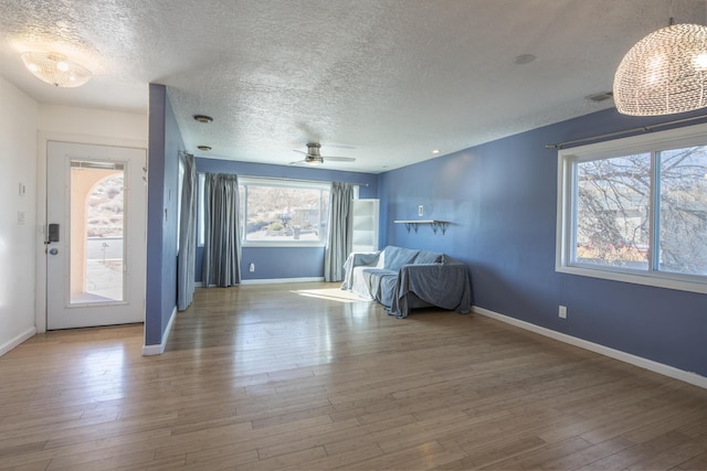 entrance foyer with a textured ceiling, baseboards, and wood finished floors