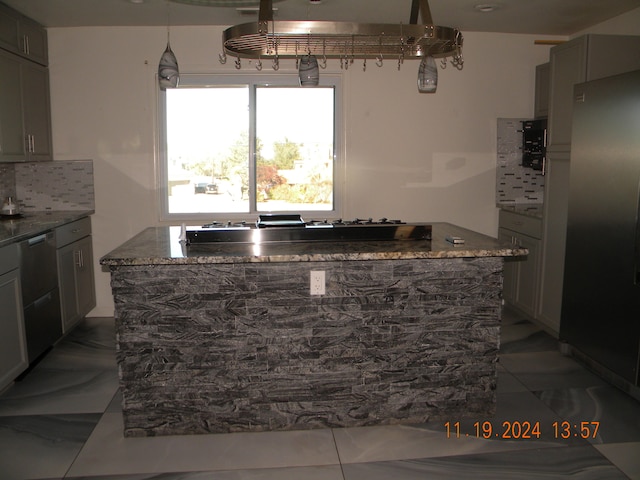 kitchen featuring tile patterned floors, dark stone countertops, backsplash, and appliances with stainless steel finishes