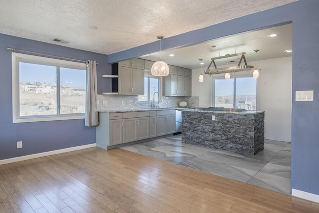 kitchen with decorative light fixtures, open shelves, visible vents, backsplash, and gray cabinetry