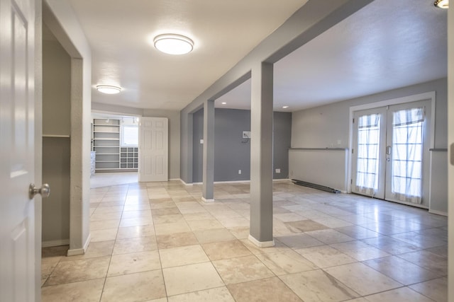 interior space featuring french doors, light tile patterned flooring, and baseboards