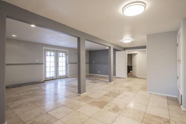 below grade area with light tile patterned floors, french doors, and baseboards