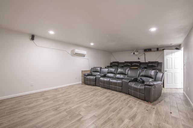 home theater featuring a wall unit AC, light wood finished floors, and baseboards