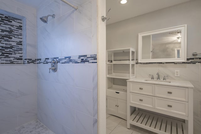 bathroom with tasteful backsplash, a tile shower, and vanity