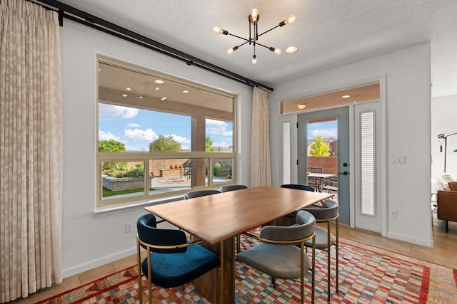 dining space featuring light tile patterned flooring, a textured ceiling, and a notable chandelier