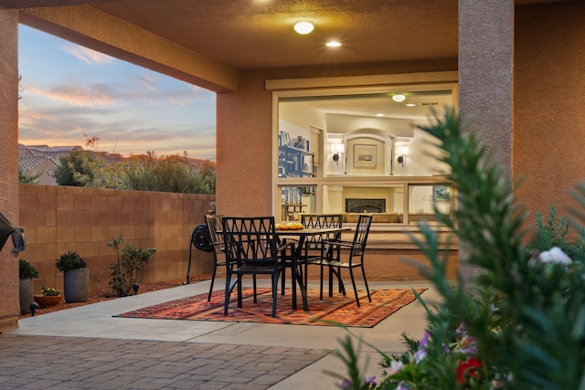 patio terrace at dusk with exterior fireplace