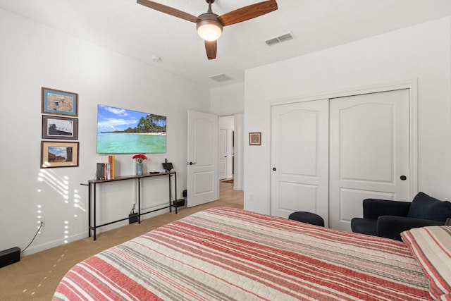 bedroom with ceiling fan, light carpet, and a closet