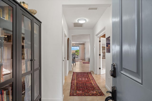 hall featuring light tile patterned flooring and a textured ceiling