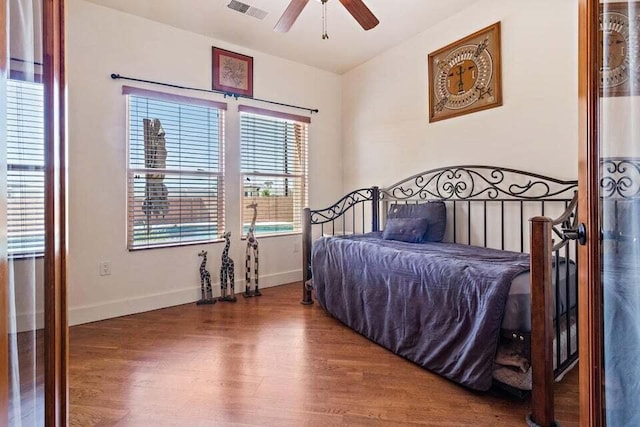 bedroom with wood-type flooring, multiple windows, and ceiling fan