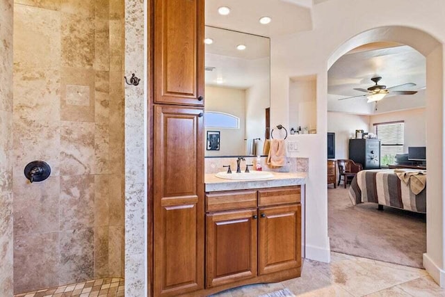 bathroom with ceiling fan, vanity, and tiled shower