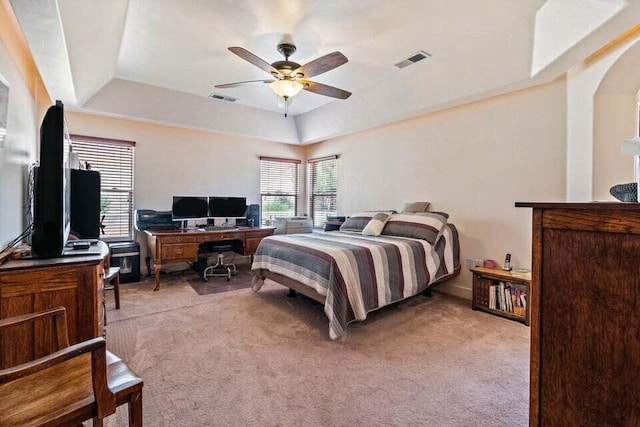 carpeted bedroom featuring ceiling fan and a tray ceiling