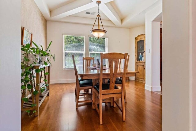 dining room with wood-type flooring, coffered ceiling, and beam ceiling