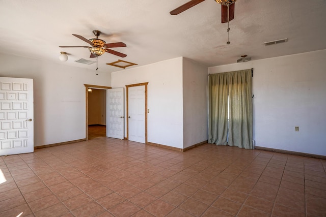 tiled empty room featuring ceiling fan and a textured ceiling