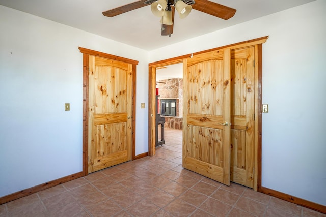 tiled empty room featuring ceiling fan