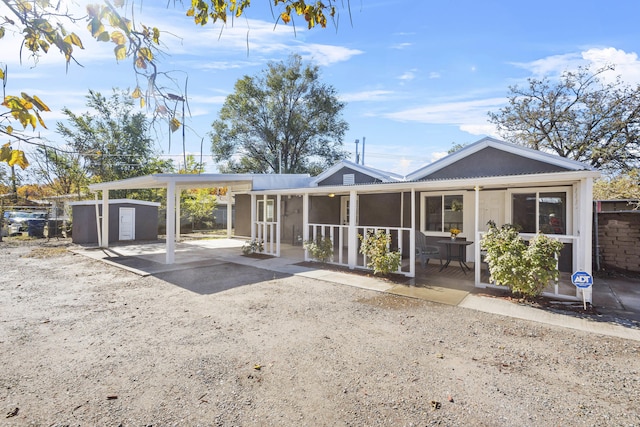 view of front facade with a carport and a storage unit