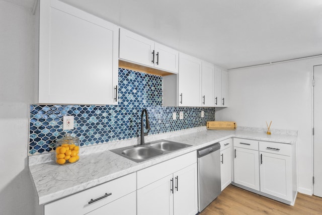 kitchen with tasteful backsplash, sink, light hardwood / wood-style flooring, dishwasher, and white cabinetry