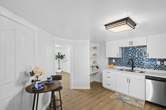 kitchen featuring tasteful backsplash, sink, hardwood / wood-style flooring, dishwasher, and white cabinetry