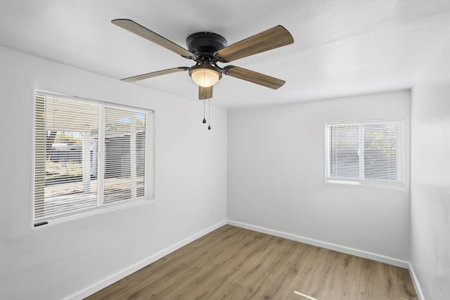 spare room with wood-type flooring, plenty of natural light, and ceiling fan