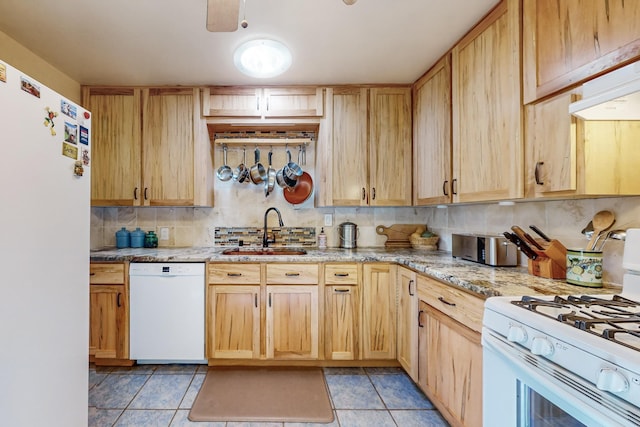 kitchen featuring tasteful backsplash, sink, light stone counters, light brown cabinets, and white appliances