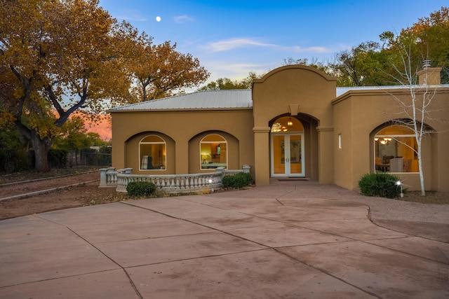 back house at dusk featuring french doors