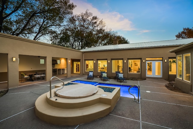 pool at dusk with a patio area