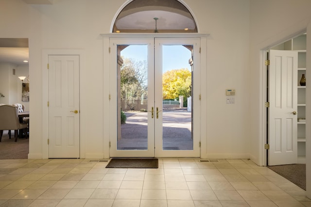 doorway to outside featuring light tile patterned flooring and french doors