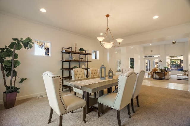 carpeted dining room featuring ornamental molding, a wealth of natural light, and a notable chandelier