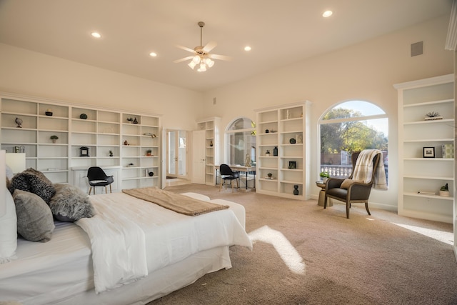 carpeted bedroom with ceiling fan and a high ceiling