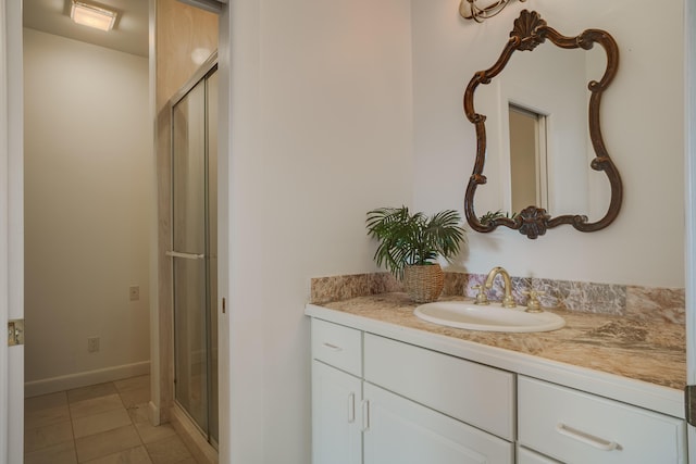 bathroom featuring tile patterned flooring, vanity, and walk in shower