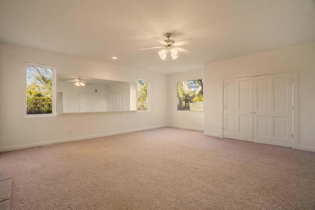 spare room featuring ceiling fan, plenty of natural light, and carpet flooring