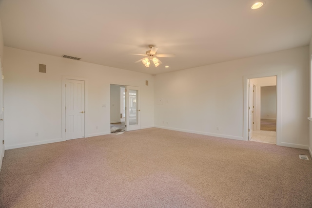 carpeted spare room featuring french doors and ceiling fan