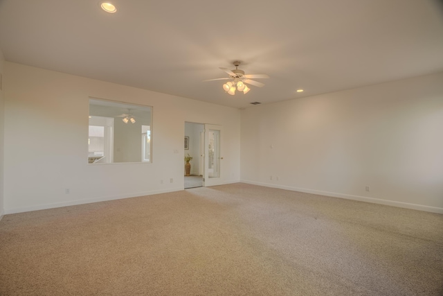 carpeted spare room featuring ceiling fan