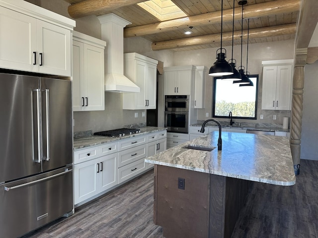 kitchen featuring stainless steel appliances, sink, an island with sink, and white cabinets