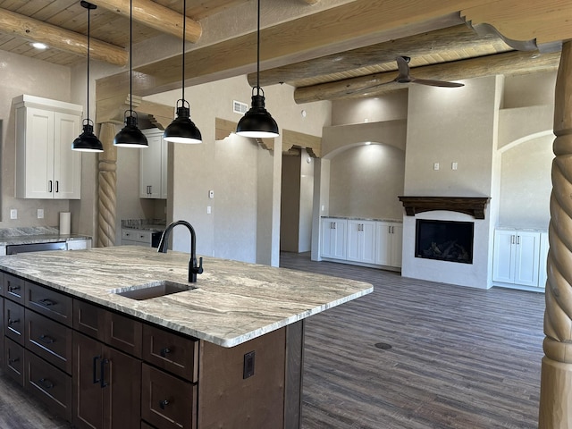 kitchen with white cabinetry, sink, a kitchen island with sink, and decorative light fixtures