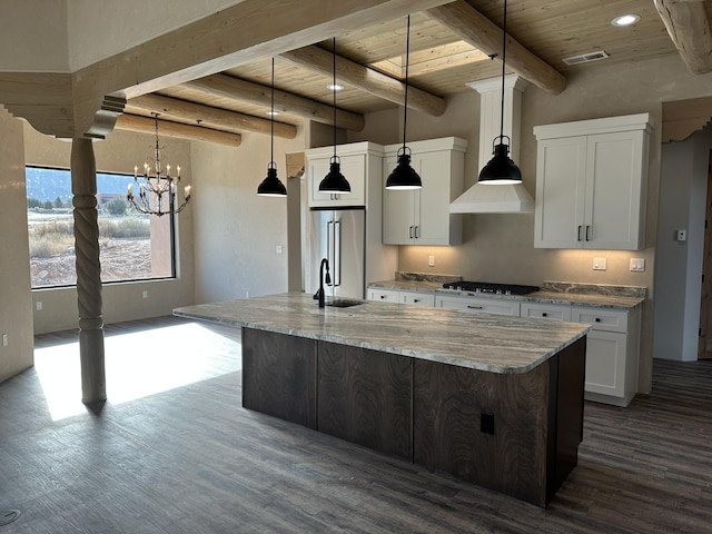 kitchen featuring white cabinetry, appliances with stainless steel finishes, decorative light fixtures, and a spacious island