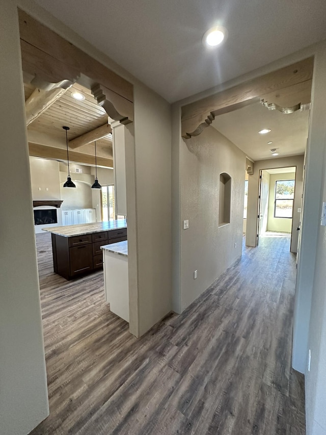 corridor featuring beam ceiling and dark wood-type flooring